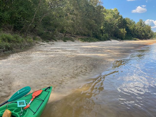 kayak on sand bank beside a small river